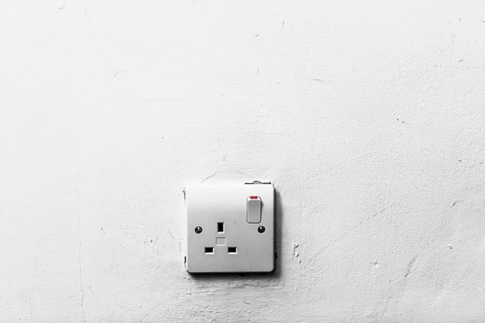 A single switched BS 1363 socket on a white painted wall
